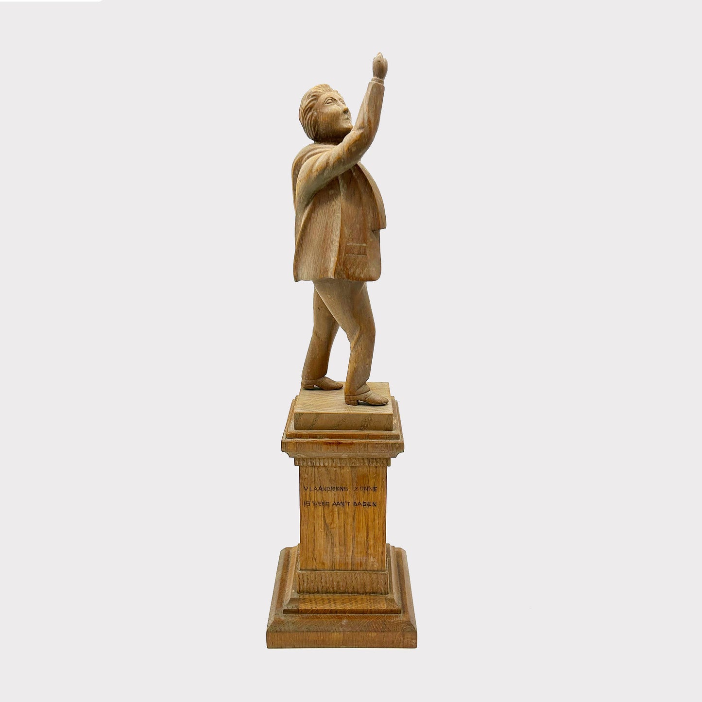 side view Wooden Statue of a Man with an inscription on the base his hand is raised up over his head